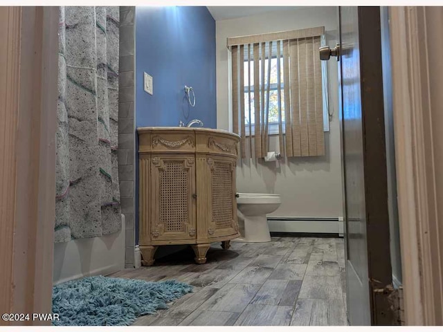 bathroom featuring toilet and a baseboard heating unit