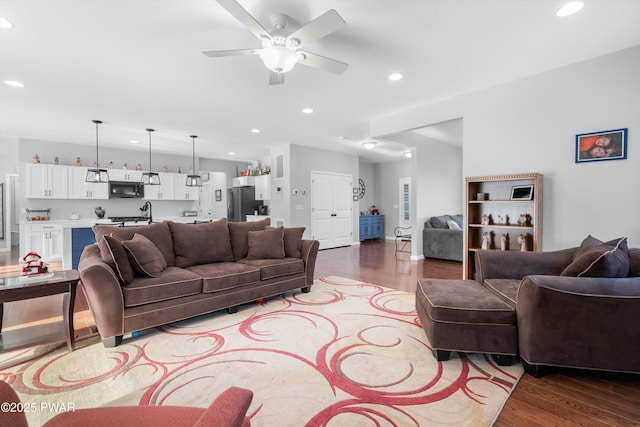 living room with ceiling fan, sink, and hardwood / wood-style floors