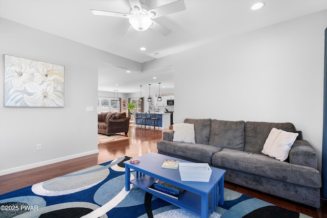 living room with ceiling fan and dark hardwood / wood-style flooring