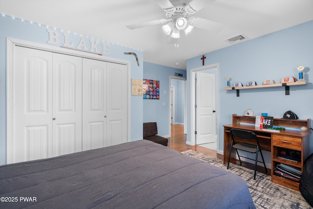 bedroom with hardwood / wood-style flooring, ceiling fan, and a closet