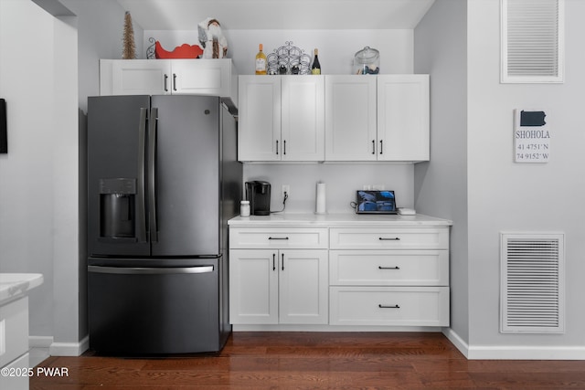 kitchen featuring dark hardwood / wood-style floors, white cabinets, and black fridge