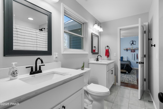 bathroom with tile patterned flooring, vanity, and toilet