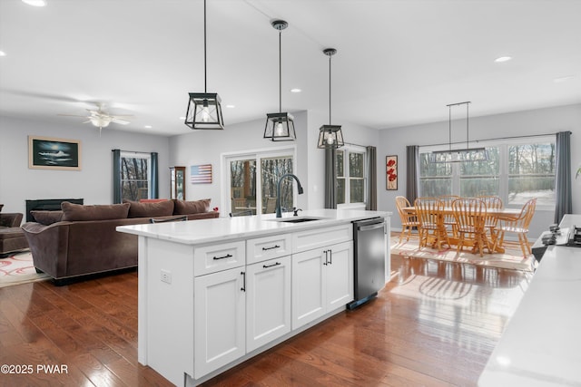 kitchen with sink, white cabinetry, an island with sink, decorative light fixtures, and stainless steel dishwasher