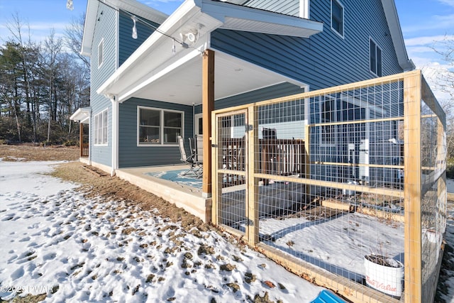 view of snow covered rear of property