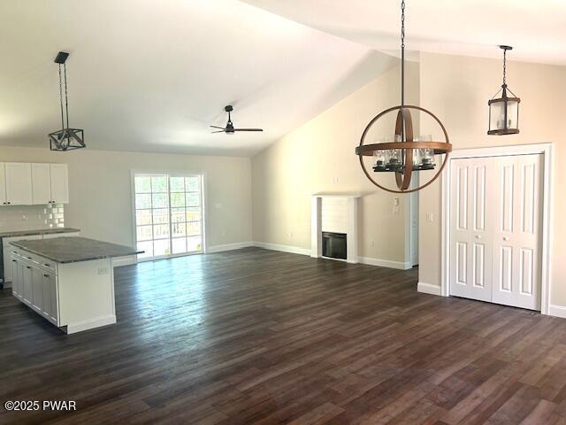 119 Lenape Dr, Milford, PA 18337 - unfurnished living room with ceiling fan, a chandelier, dark wood-style flooring, a fireplace, and high vaulted ceiling