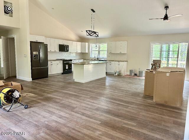 119 Lenape Dr, Milford, PA 18337 - kitchen with black fridge, range, a ceiling fan, dark wood-style floors, and high vaulted ceiling