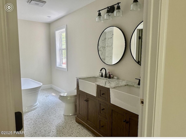 119 Lenape Dr, Milford, PA 18337 - bathroom featuring double vanity, a freestanding bath, and speckle patterned floor
