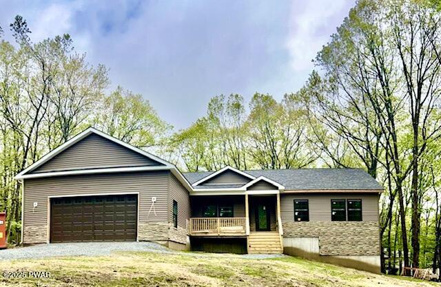 119 Lenape Dr, Milford, PA 18337 - single story home with a porch, an attached garage, and gravel driveway