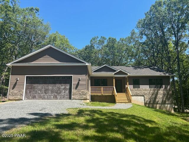 119 Lenape Dr, Milford, PA 18337 - ranch-style home featuring a porch, stone siding, gravel driveway, a front lawn, and an attached garage