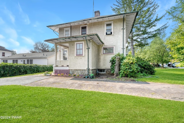 rear view of house featuring a yard