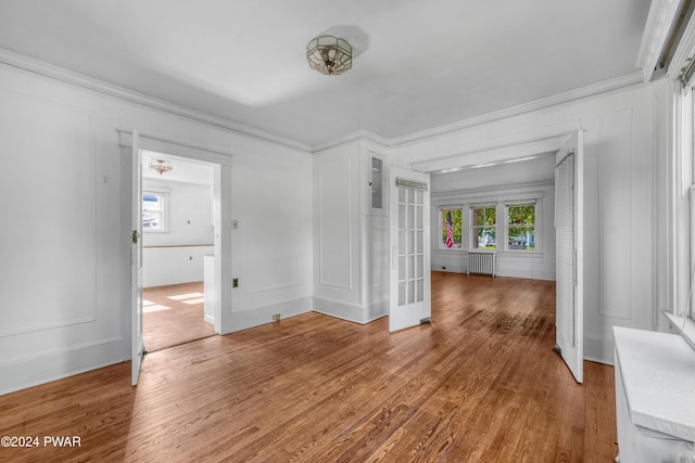 spare room featuring hardwood / wood-style flooring, crown molding, and radiator