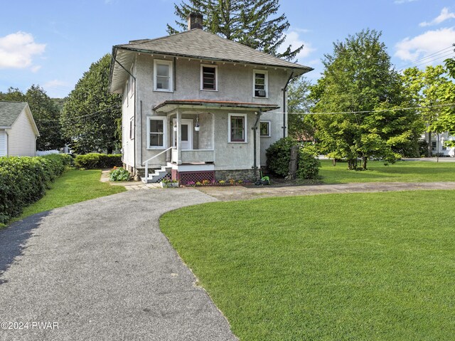 view of front facade with covered porch and a front lawn