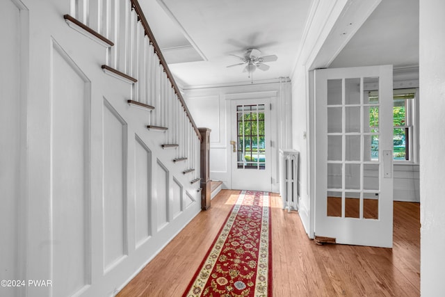 entrance foyer with light wood-type flooring, crown molding, ceiling fan, and a healthy amount of sunlight