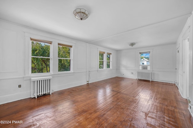 spare room with dark hardwood / wood-style flooring and radiator heating unit