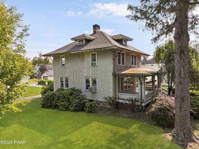 rear view of house with a yard and cooling unit