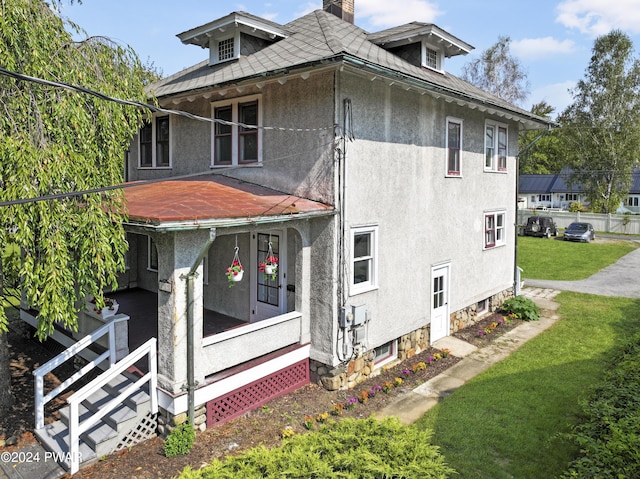 back of house featuring a lawn