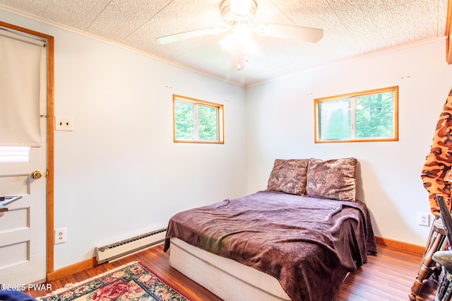 114 Springbrook Ln, Greentown, PA 18426 - bedroom featuring a baseboard heating unit, ornamental molding, wood finished floors, and a ceiling fan
