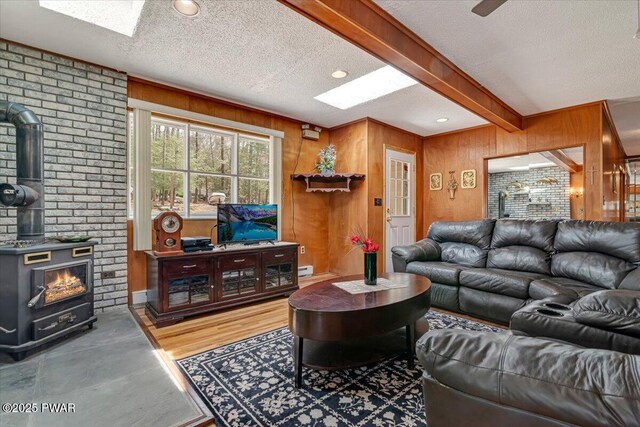111 N Redwood Dr, Greentown, PA 18426 - living area featuring wood walls, a wood stove, a textured ceiling, a skylight, and beam ceiling
