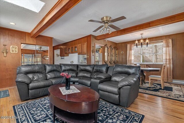 111 N Redwood Dr, Greentown, PA 18426 - living area with ceiling fan with notable chandelier, beam ceiling, wood walls, and wood finished floors