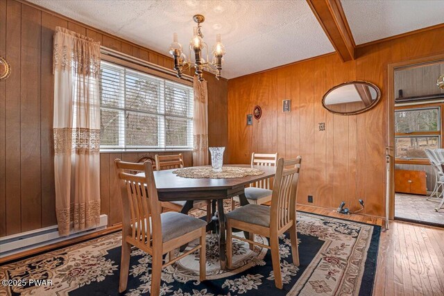 111 N Redwood Dr, Greentown, PA 18426 - dining room with a textured ceiling, wood walls, a chandelier, beamed ceiling, and wood-type flooring