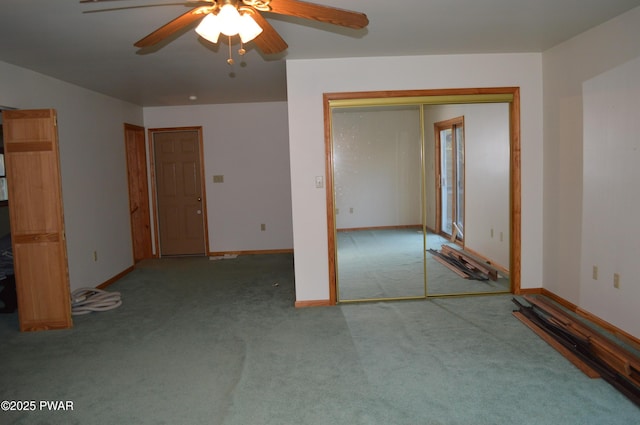 unfurnished bedroom with a closet, carpet flooring, ceiling fan, and baseboards