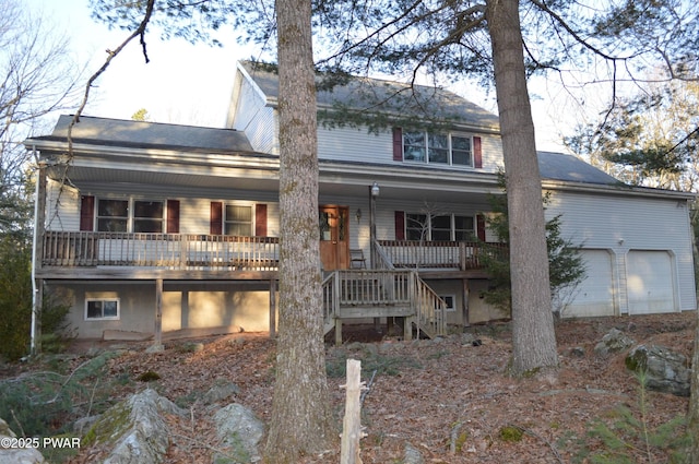 rear view of property featuring a garage, a porch, and stairs