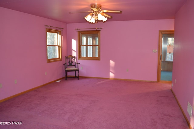 empty room featuring baseboards, light carpet, and ceiling fan