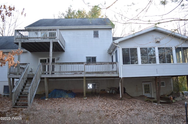 back of property featuring stairway, central air condition unit, roof with shingles, a deck, and a sunroom