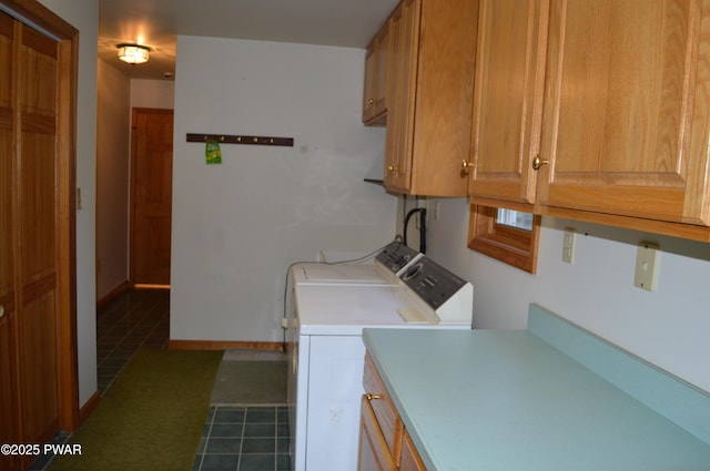 washroom with baseboards, cabinet space, and washer and clothes dryer