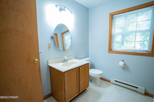 bathroom with vanity, toilet, and a baseboard heating unit