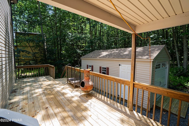 wooden deck featuring a garage and an outdoor structure