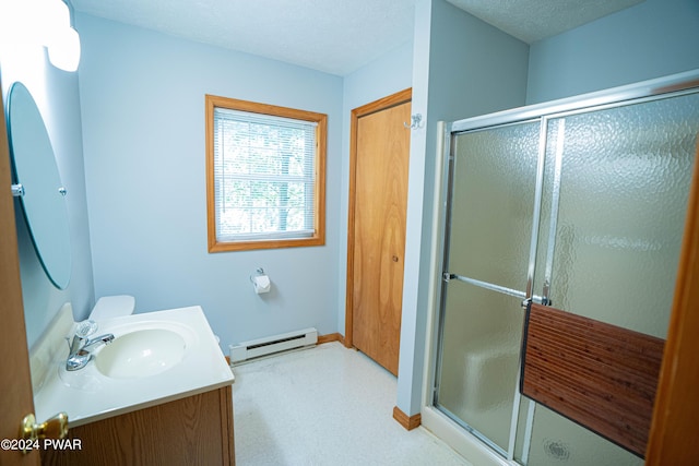 bathroom featuring vanity, a shower with door, a textured ceiling, and a baseboard heating unit