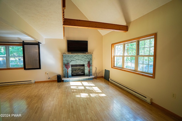 unfurnished living room with vaulted ceiling with beams, a fireplace, light hardwood / wood-style floors, and a baseboard heating unit