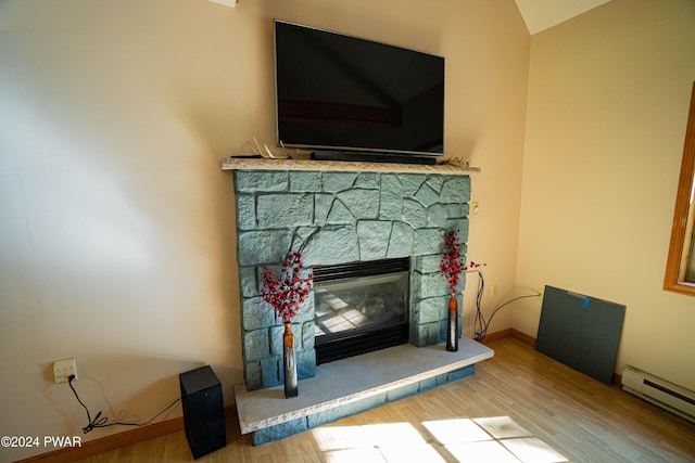 interior details featuring a stone fireplace, hardwood / wood-style floors, and a baseboard radiator