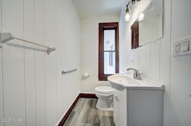 bathroom with wood-type flooring, vanity, and toilet