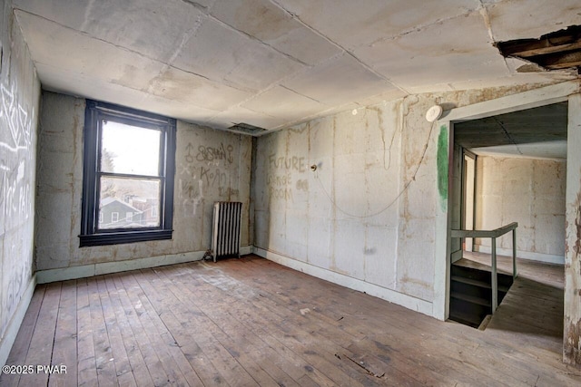 unfurnished room with hardwood / wood-style flooring and radiator