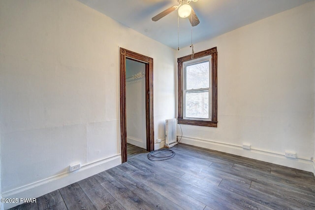 unfurnished room featuring radiator, dark wood-type flooring, and ceiling fan