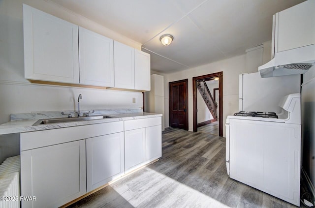 kitchen featuring sink, white gas stove, white cabinetry, light wood-type flooring, and custom range hood