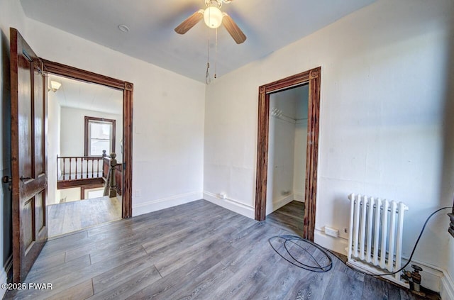 empty room featuring radiator, hardwood / wood-style flooring, and ceiling fan