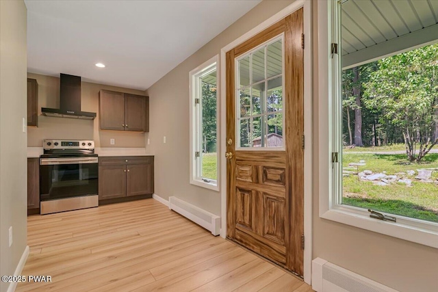 1039 Towpath Rd, Hawley, PA 18428 - kitchen with stainless steel electric range, wall chimney exhaust hood, light wood-type flooring, a baseboard radiator, and light countertops