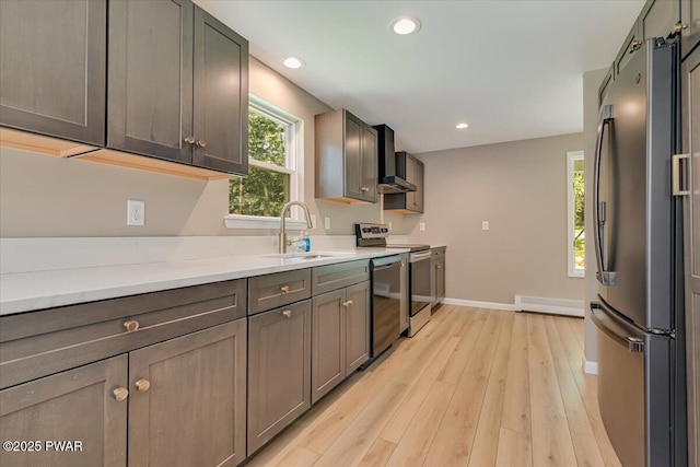 1039 Towpath Rd, Hawley, PA 18428 - kitchen featuring appliances with stainless steel finishes, wall chimney exhaust hood, light wood-style floors, recessed lighting, and a baseboard heating unit