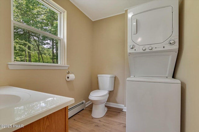 1039 Towpath Rd, Hawley, PA 18428 - bathroom featuring a baseboard heating unit, stacked washer / drying machine, wood finished floors, healthy amount of natural light, and crown molding