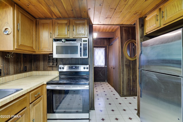 1086 Hampstead Rd, Bushkill, PA 18324 - kitchen featuring stainless steel appliances, light floors, wooden ceiling, wood walls, and brown cabinets