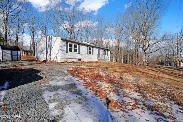 snow covered property with a shed