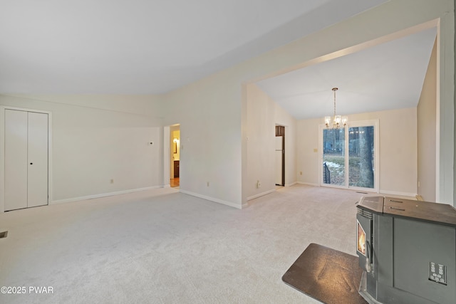 unfurnished living room with lofted ceiling, light carpet, and a notable chandelier