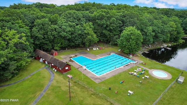 view of swimming pool with a storage shed and a water view