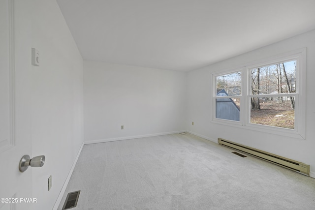 spare room with light carpet and a baseboard radiator