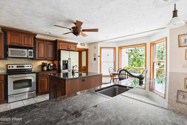 119 Canoebrook Dr, Hawley, PA 18428 - kitchen with stainless steel appliances, decorative backsplash, a ceiling fan, light tile patterned flooring, and dark stone counters