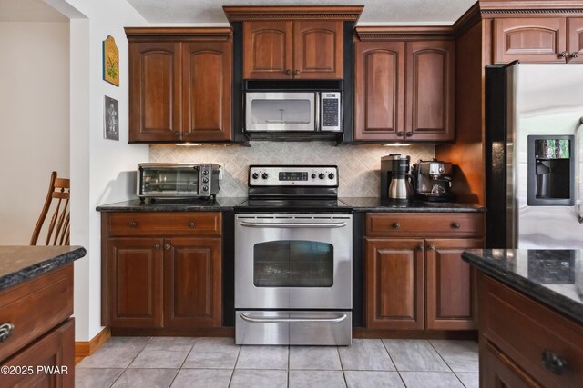 119 Canoebrook Dr, Hawley, PA 18428 - kitchen featuring appliances with stainless steel finishes, decorative backsplash, dark stone counters, and light tile patterned floors