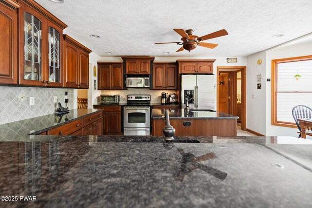 119 Canoebrook Dr, Hawley, PA 18428 - kitchen with stainless steel appliances, glass insert cabinets, backsplash, dark stone countertops, and recessed lighting